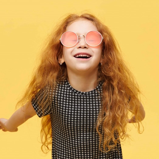 carefree-fashionable-little-girl-with-curly-red-hair-scaled.jpg